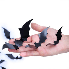Black PVC bat stickers in multiple sizes held in an open palm showing 3D wing detail and scale