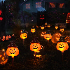 Solar pumpkin light glowing along a garden pathway