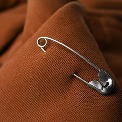 Heavy duty safety pin securing thick fabric or denim
