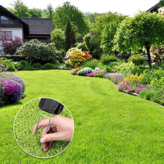 Hand pressing a galvanized steel garden staple into lawn grass in a well-maintained backyard garden